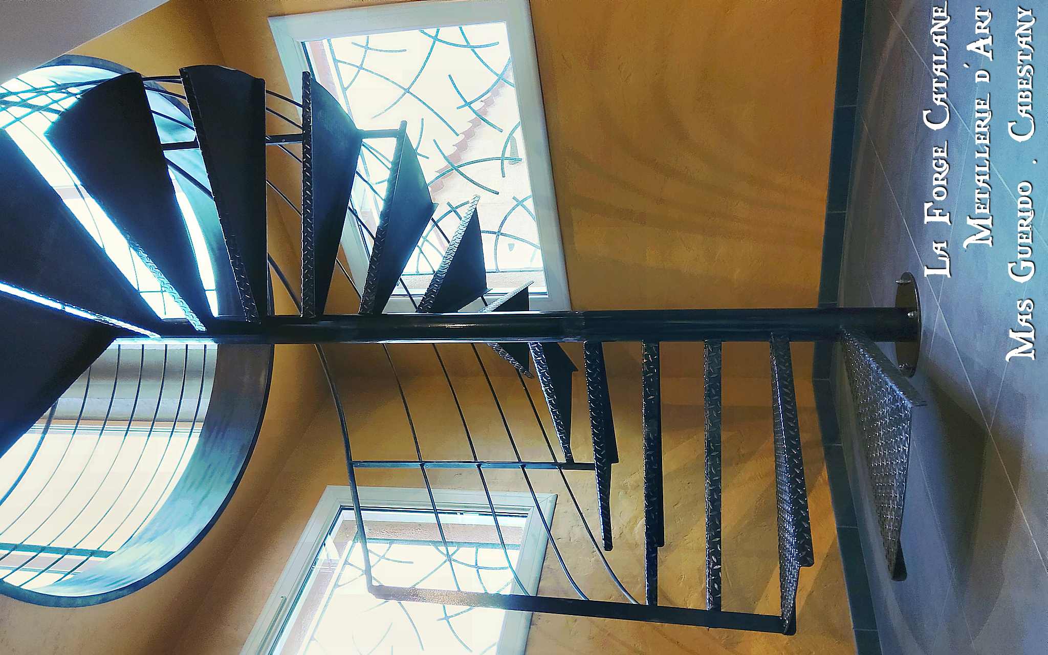 escalier colimacon en fer avec rampant peripherique et capotage de finition bord de tremie forge catalane.jpg